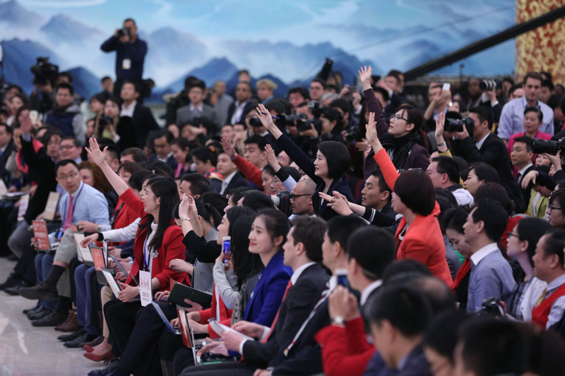 3月15日，國務院總理李克強在北京人民大會堂與中外記者見面，并回答記者提問。這是記者舉手爭取提問機會。 新華社記者 才揚 攝